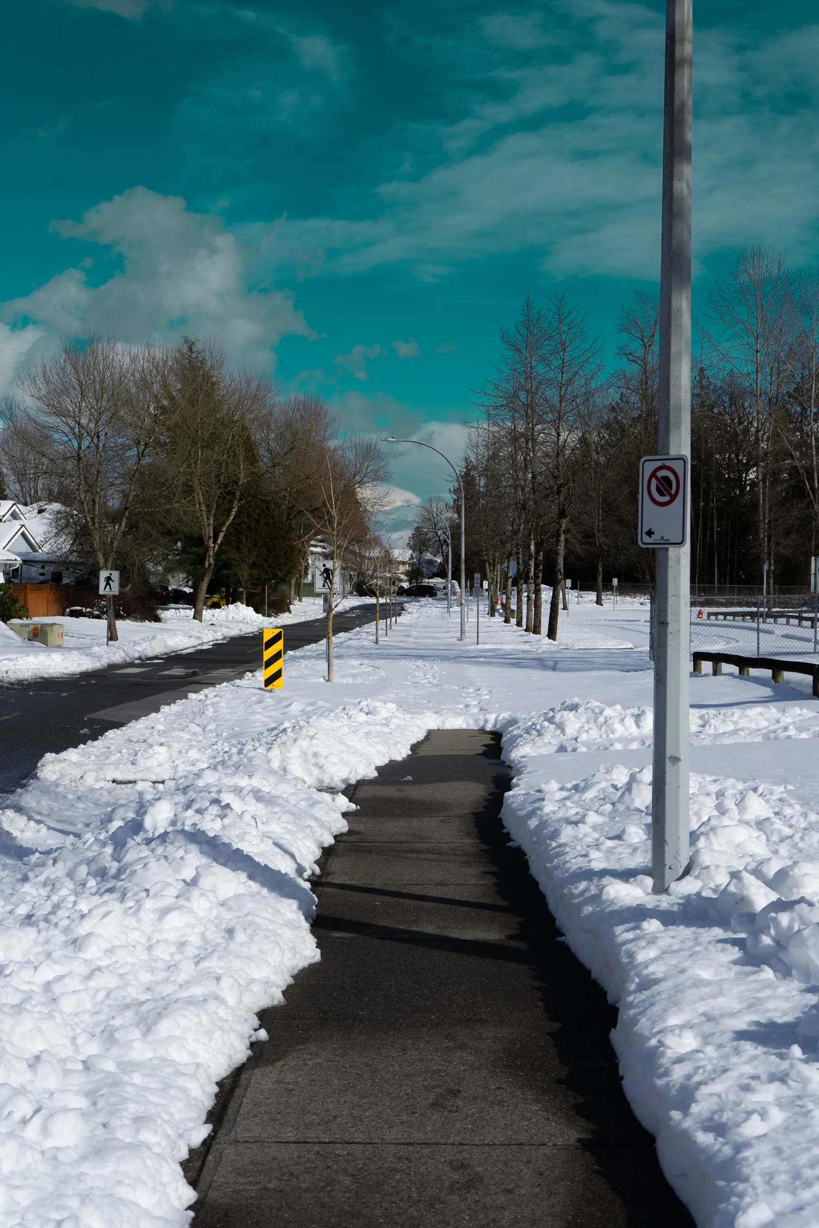 Snowy sidewalk under a blue sky