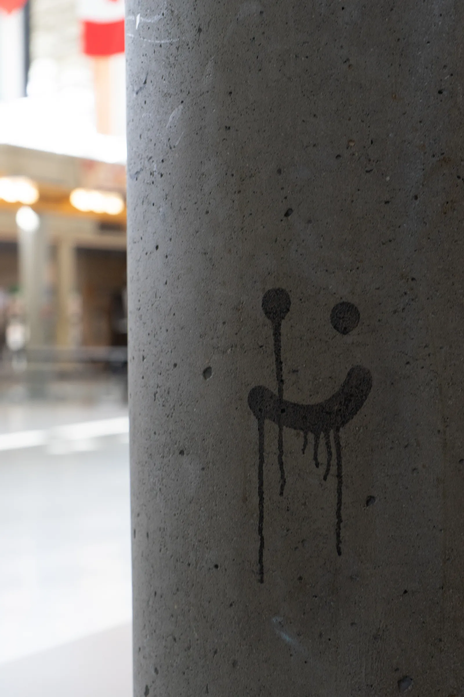 Smiley face drawn on a concrete pole
